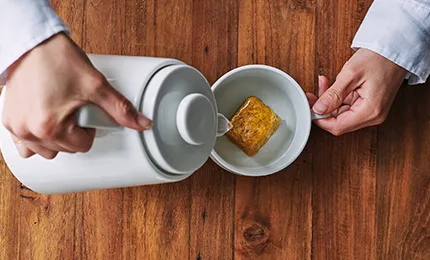 フリーズドライのお味噌汁にお湯を注いでいる写真