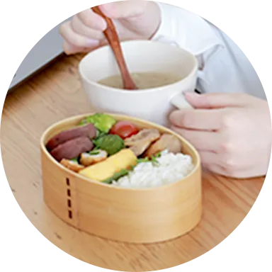 職場でのランチタイムにお味噌汁を食べているイメージ写真